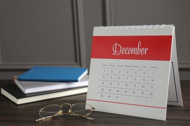 Photo of Timetable. Monthly planner, notebooks and glasses on wooden table