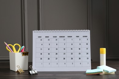 Photo of Timetable. Monthly planner and stationery on wooden table