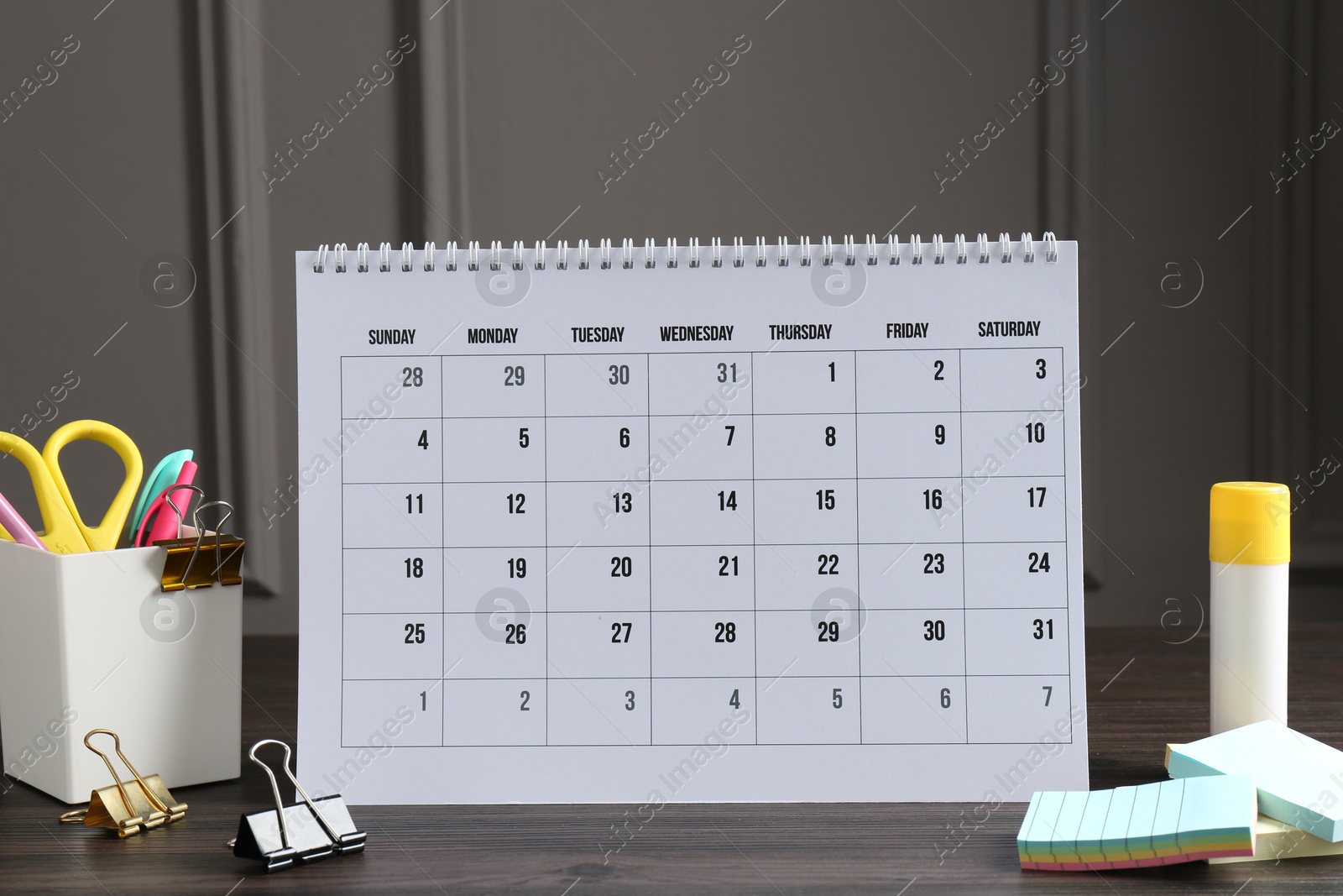 Photo of Timetable. Monthly planner and stationery on wooden table