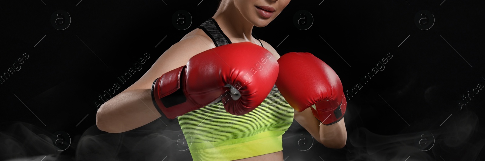 Image of Woman in boxing gloves training on black background, closeup. Banner design