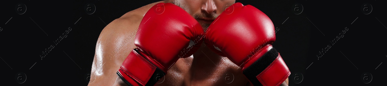 Image of Man in boxing gloves on black background, closeup. Banner design