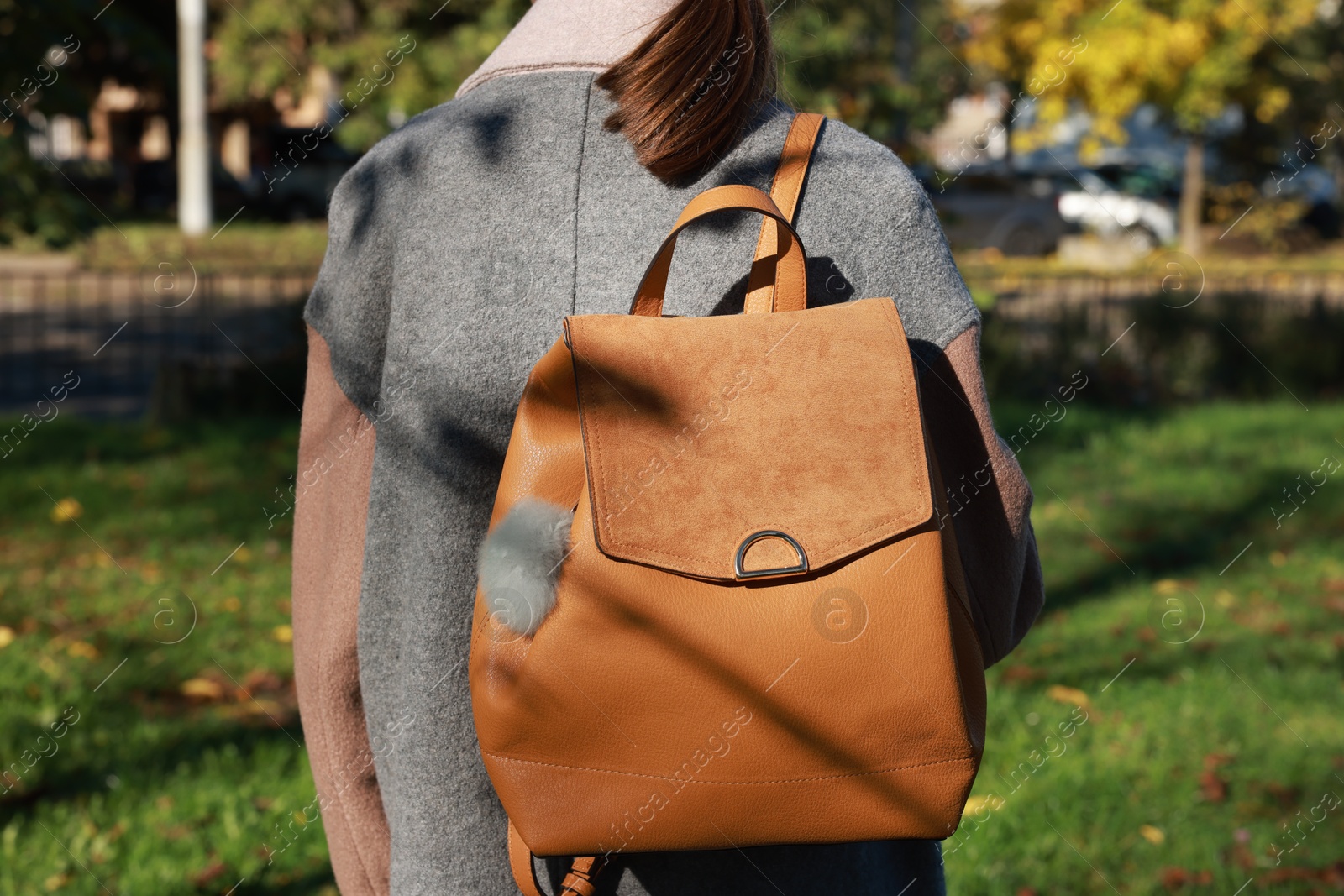 Photo of Woman with faux fur keychain on her backpack outdoors, closeup