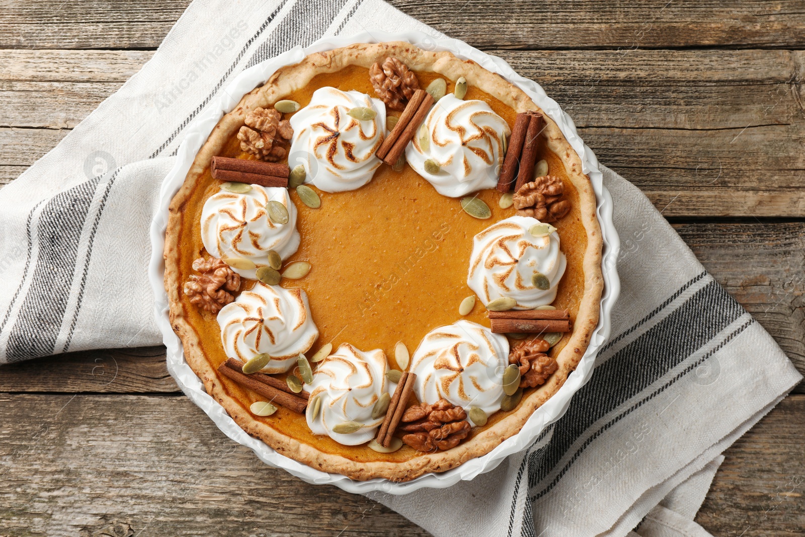 Photo of Tasty homemade pumpkin pie in baking dish on wooden table, top view