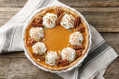 Photo of Tasty homemade pumpkin pie in baking dish on wooden table, top view