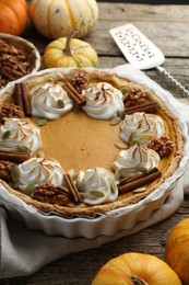 Tasty homemade pumpkin pie, ingredients and cake server on wooden table, closeup