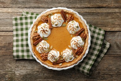 Delicious homemade pumpkin pie in baking dish on wooden table, top view