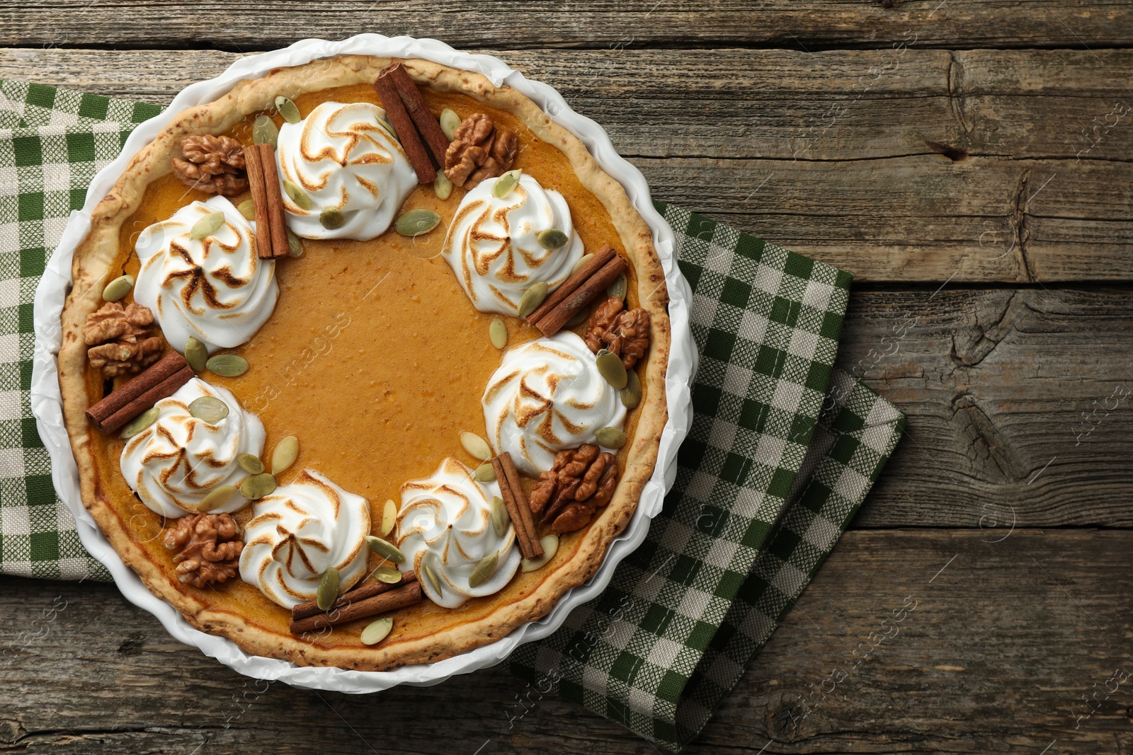 Photo of Delicious homemade pumpkin pie in baking dish on wooden table, top view. Space for text