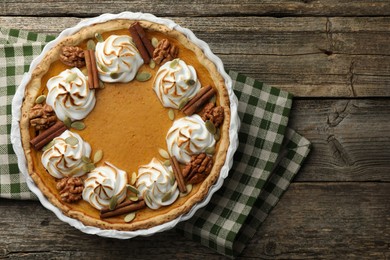 Delicious homemade pumpkin pie in baking dish on wooden table, top view. Space for text