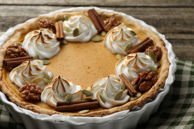 Delicious homemade pumpkin pie in baking dish on wooden table, closeup