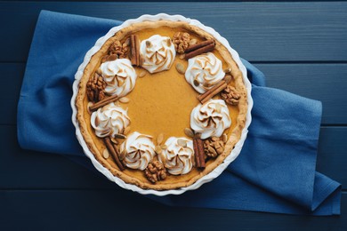 Photo of Delicious homemade pumpkin pie in baking dish on blue wooden table, top view