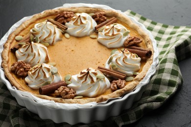 Delicious homemade pumpkin pie in baking dish on black table, closeup