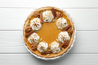 Photo of Delicious homemade pumpkin pie in baking dish on white wooden table, top view