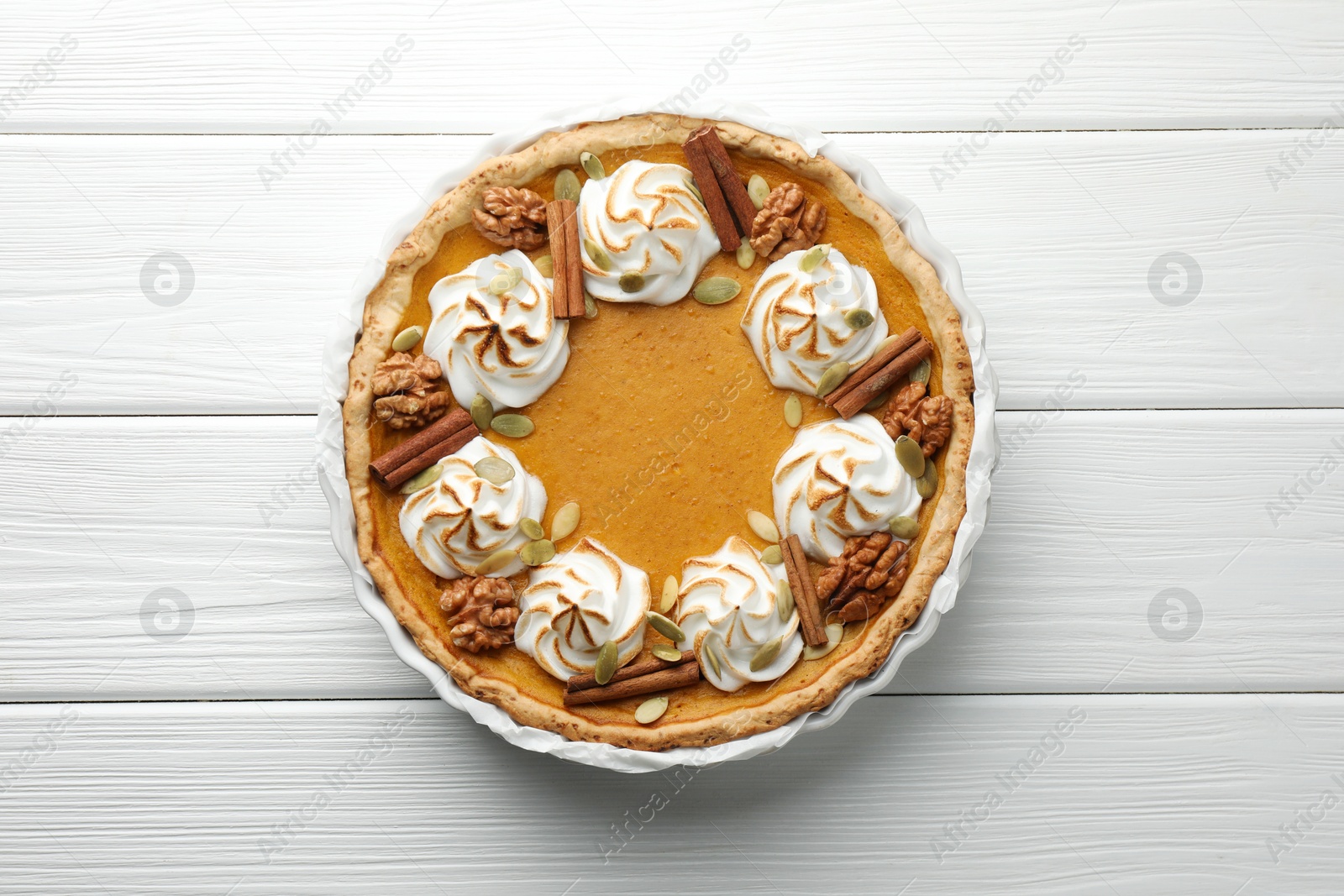 Photo of Delicious homemade pumpkin pie in baking dish on white wooden table, top view