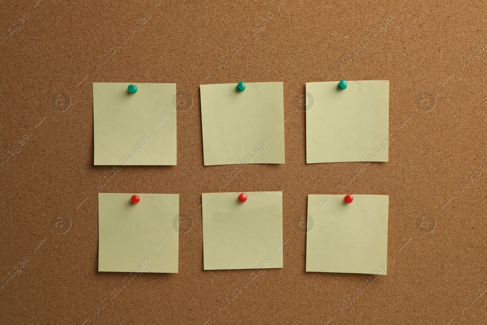 Photo of Beige paper notes pinned to cork board