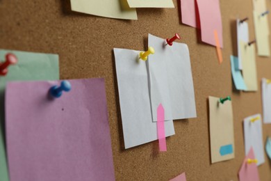 Photo of Colorful paper notes pinned to cork board, closeup