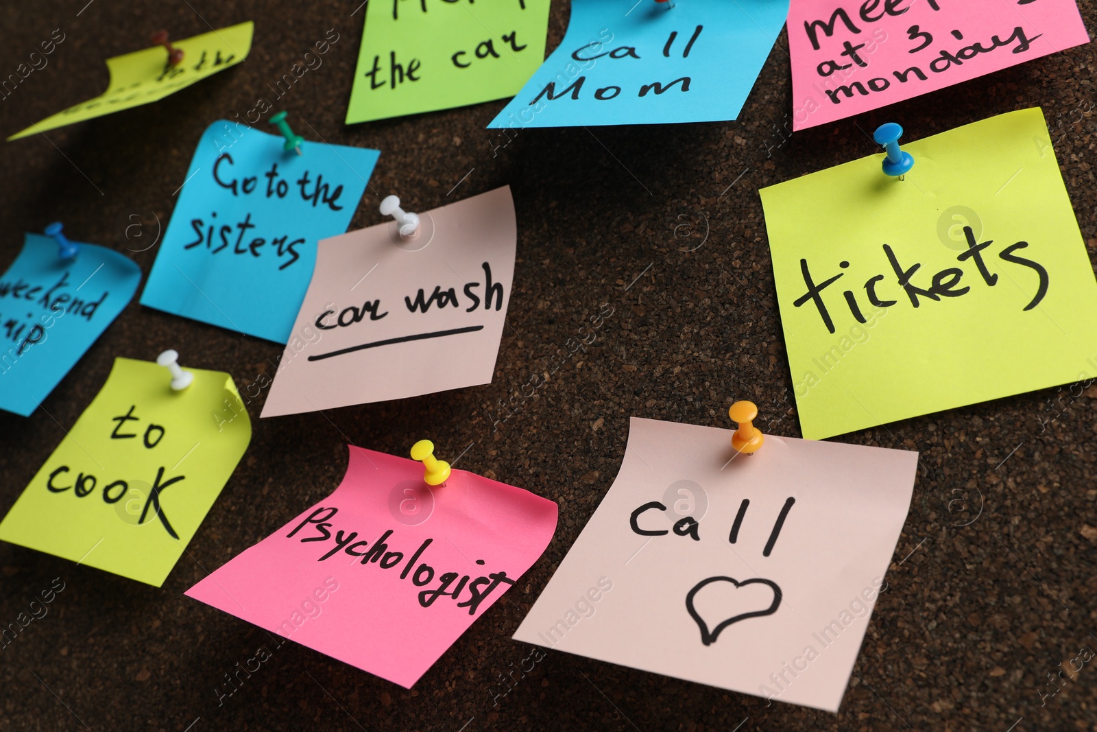 Photo of Colorful reminder notes pinned to cork board