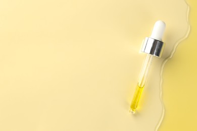 Photo of Cosmetic oil and pipette on dark beige background, top view. Space for text