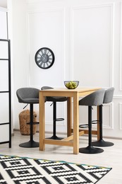 Photo of Bar stools and table near white wall