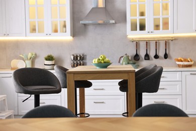 Photo of Bar stools near table in stylish kitchen