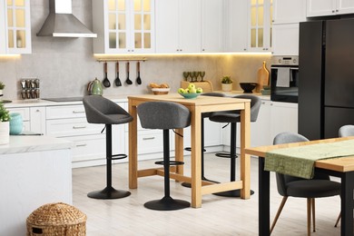 Photo of Bar stools near table in stylish kitchen