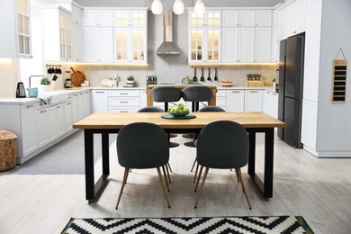 Photo of Bar stools, tables and other furniture in stylish kitchen