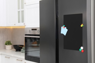 Photo of Magnetic board and notes on refrigerator in kitchen