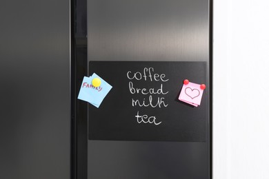 Photo of Magnetic board with shopping list and notes on refrigerator