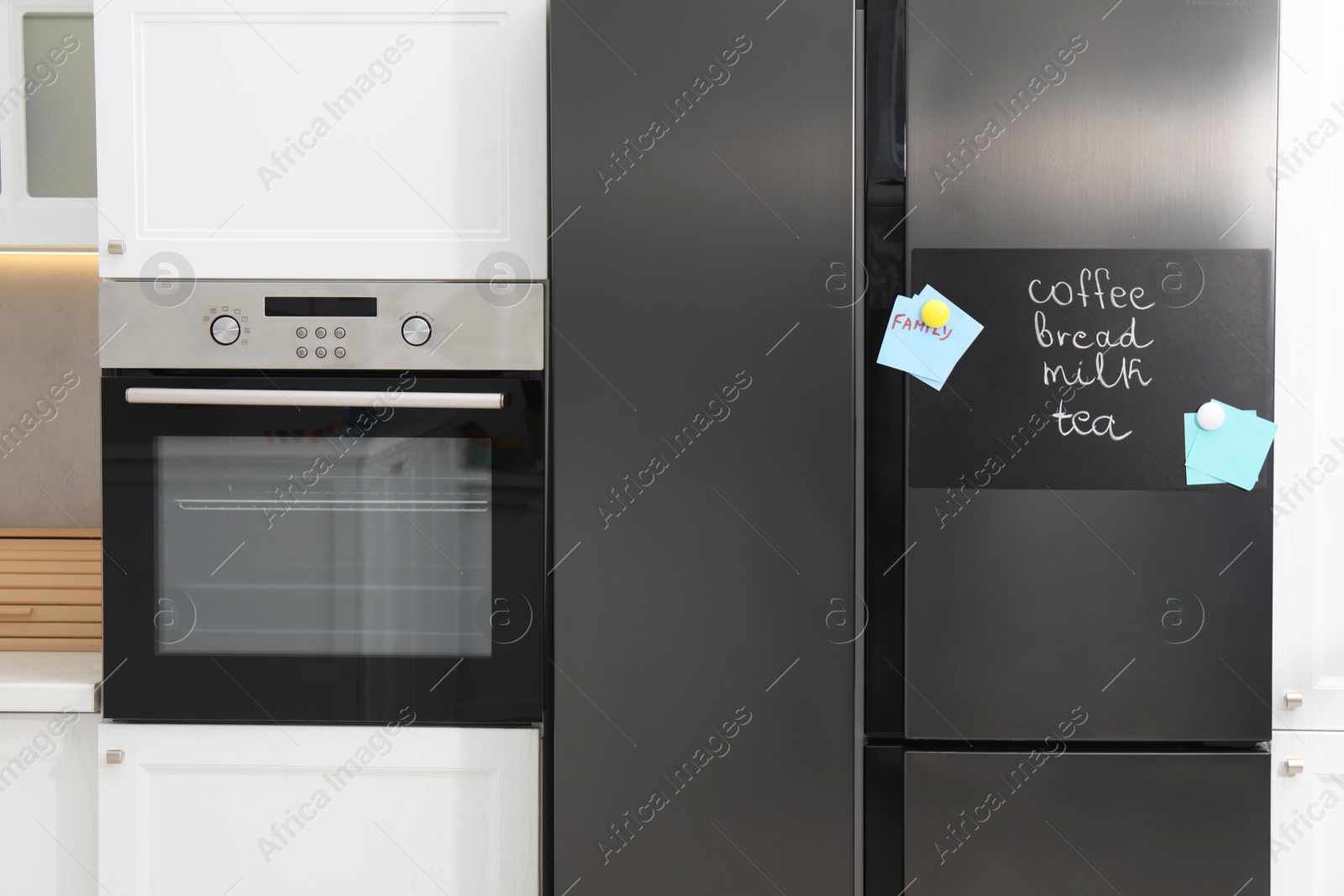 Photo of Magnetic board with shopping list and notes on refrigerator in kitchen