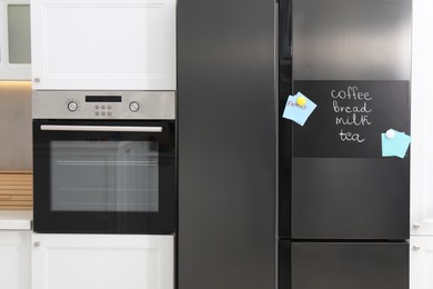 Magnetic board with shopping list and notes on refrigerator in kitchen