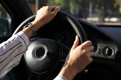 Photo of Woman holding steering wheel while driving car, closeup