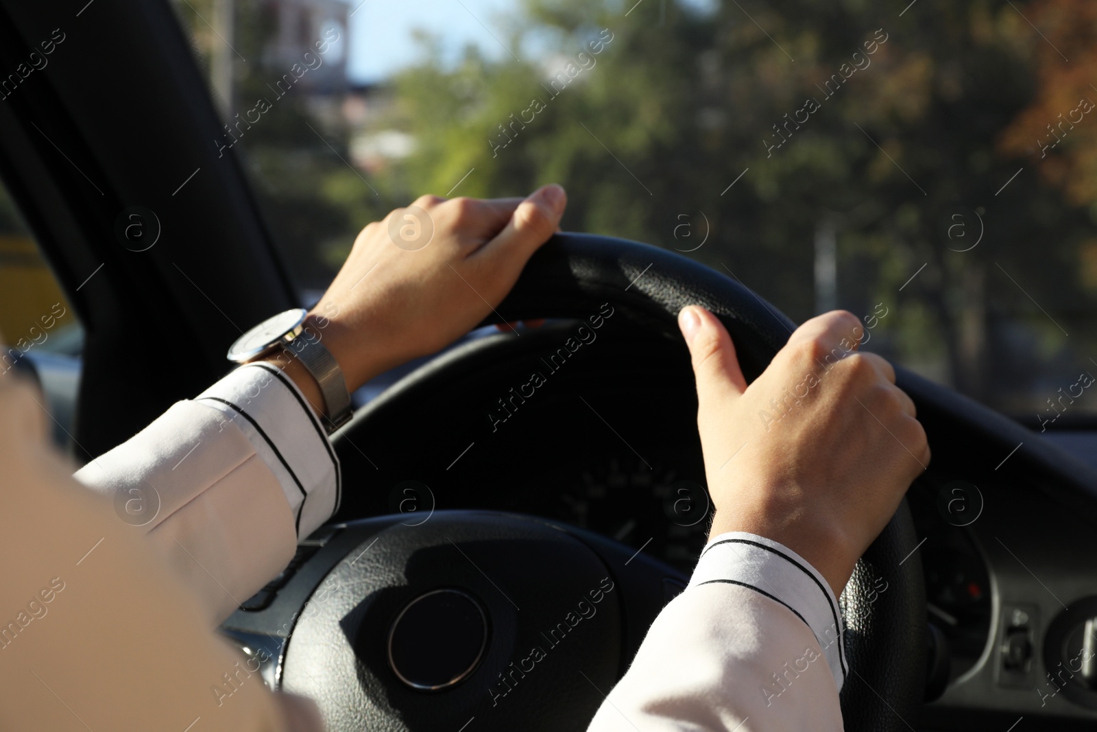 Photo of Woman holding steering wheel while driving car, closeup