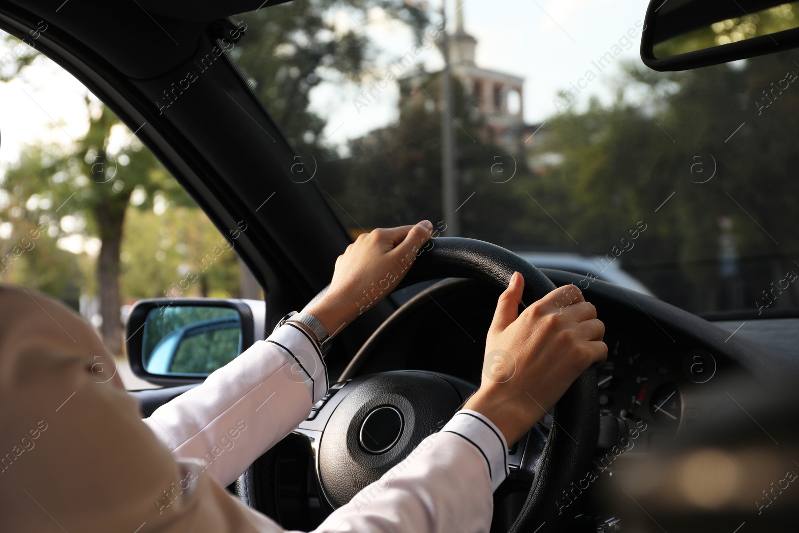 Photo of Woman holding steering wheel while driving car, closeup