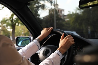 Photo of Woman holding steering wheel while driving car, closeup