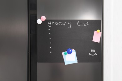 Magnetic board with grocery list and notes on refrigerator in kitchen