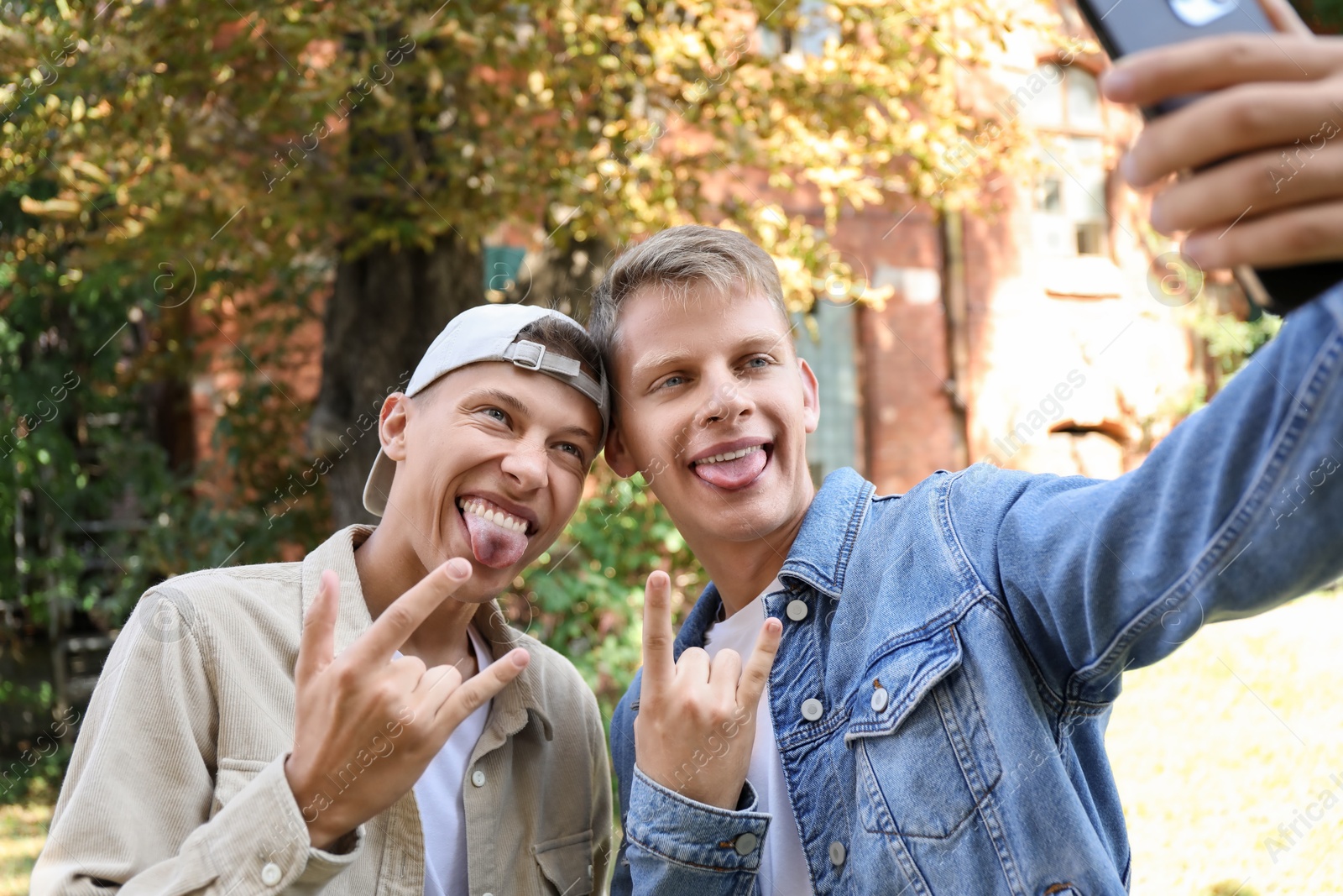 Photo of Happy brothers taking selfie and gesturing outdoors