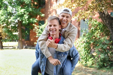 Happy brothers spending time together outdoors on sunny day