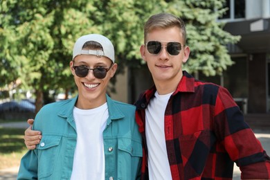 Family portrait of happy brothers in sunglasses outdoors