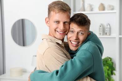 Family portrait of happy brothers hugging at home. Space for text