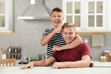 Photo of Family portrait of happy brothers in kitchen