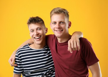 Photo of Portrait of happy brothers on orange background