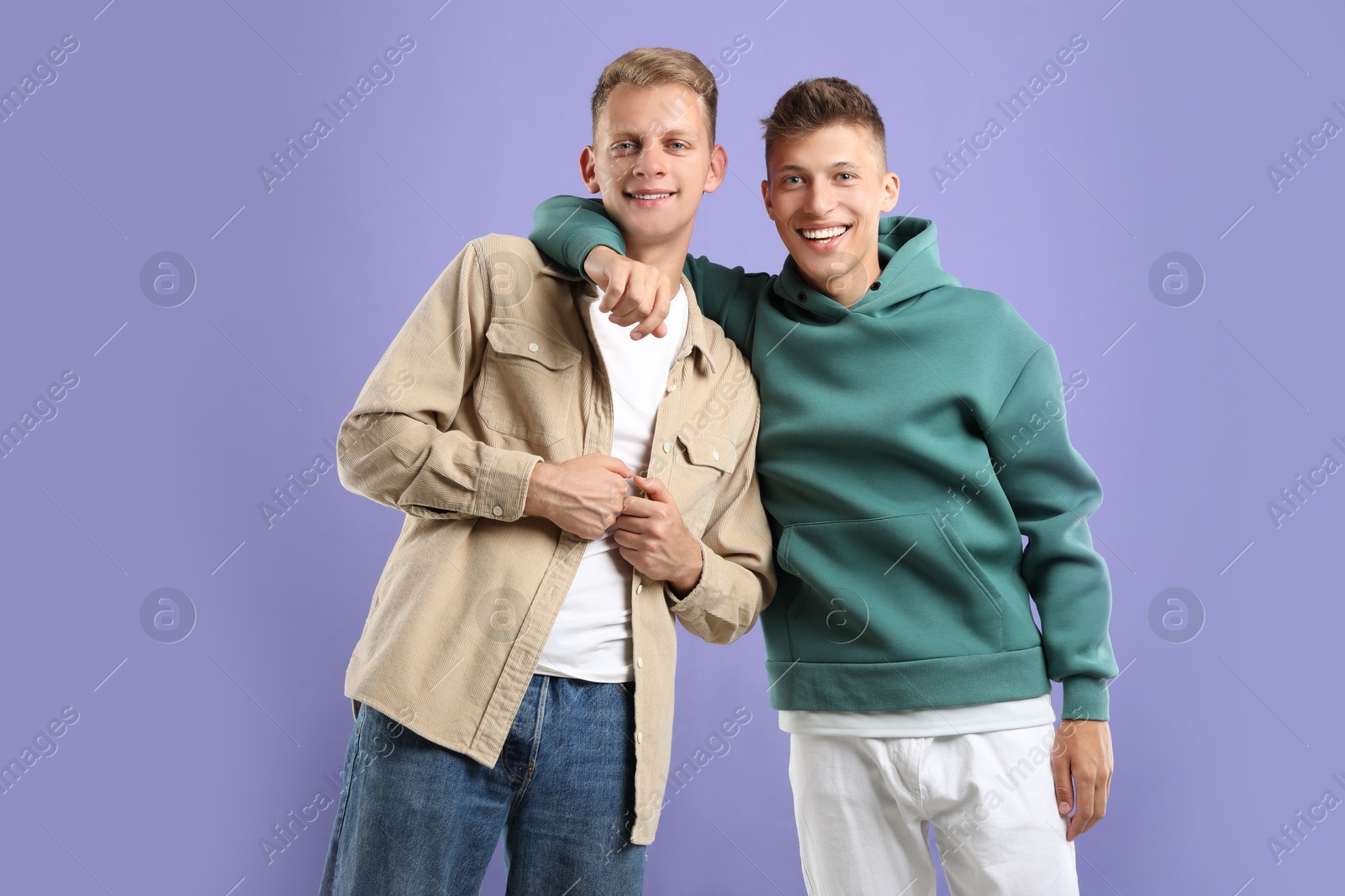 Photo of Portrait of happy brothers on violet background