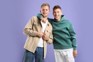 Portrait of happy brothers on violet background