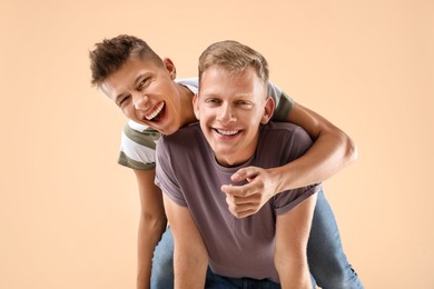 Photo of Portrait of happy brothers on beige background