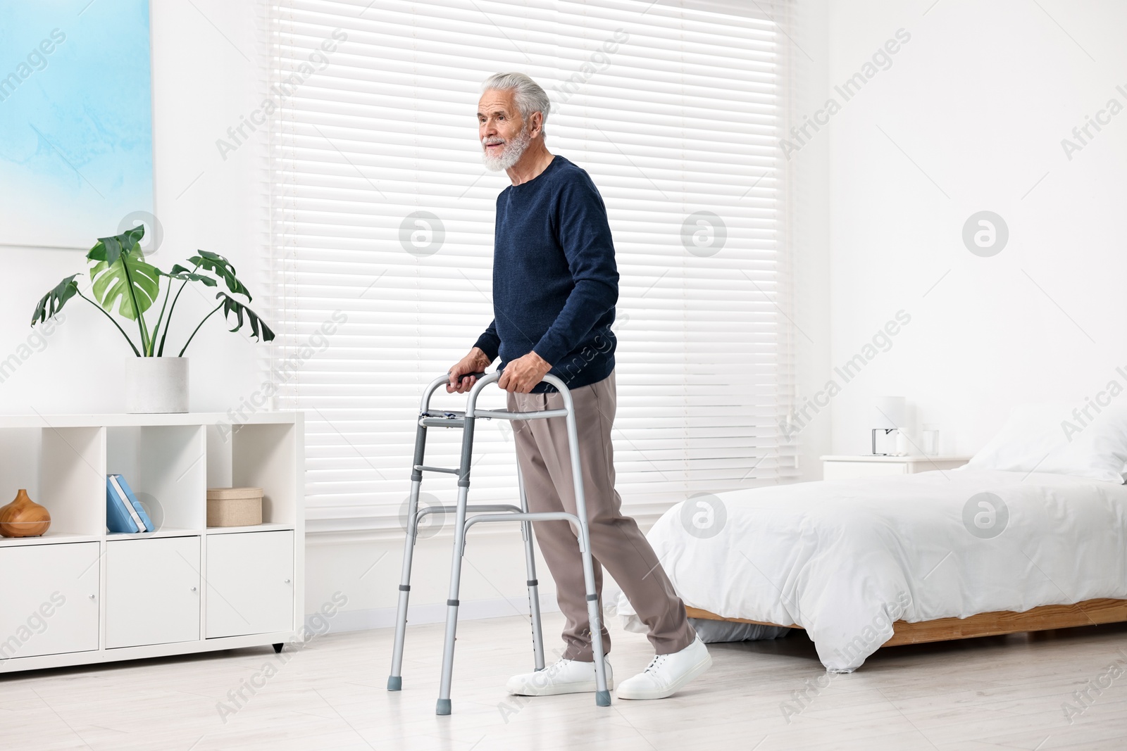 Photo of Senior man with walking frame in hospital ward