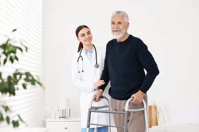 Doctor helping senior man with walking frame in clinic