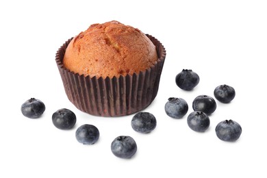 Photo of Delicious sweet muffin and blueberries isolated on white