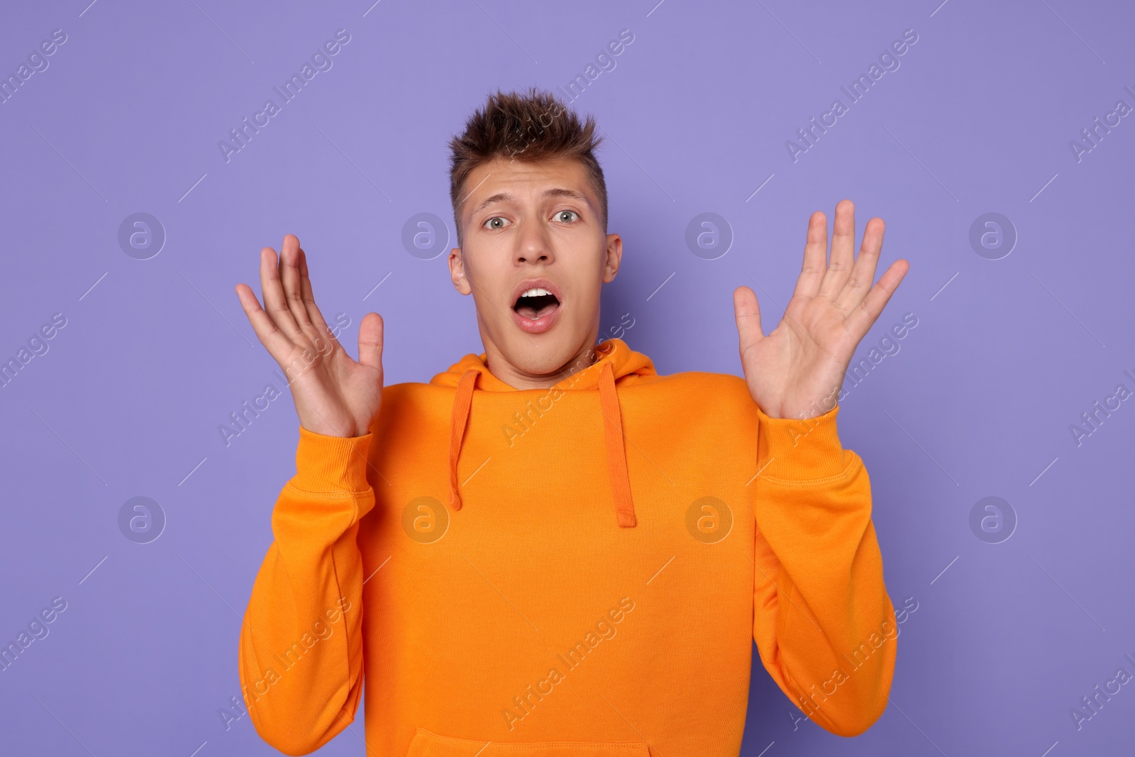 Photo of Portrait of scared young man on violet background