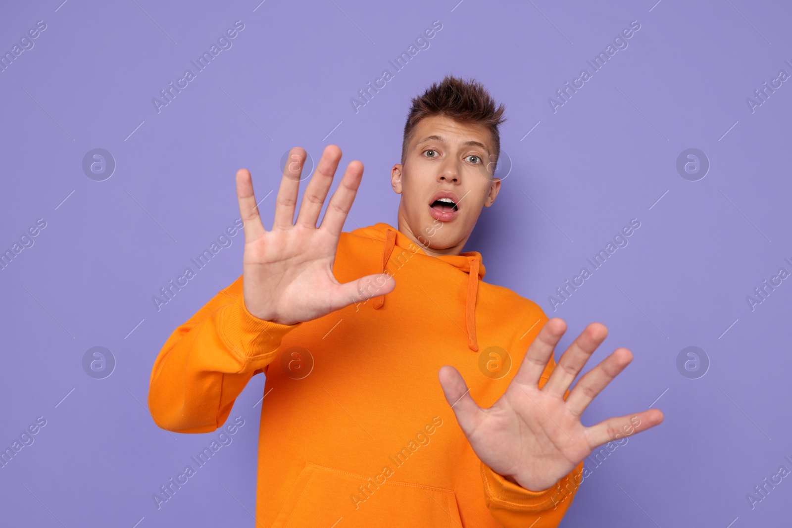 Photo of Portrait of scared young man on violet background