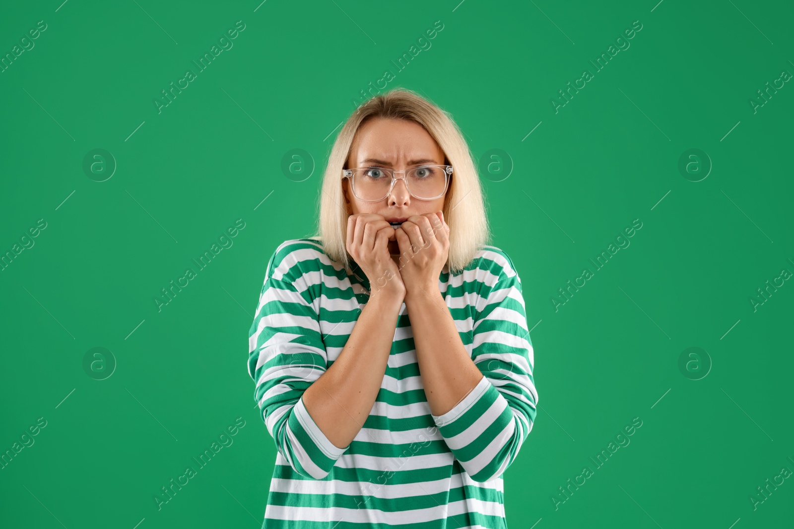 Photo of Portrait of scared woman on green background