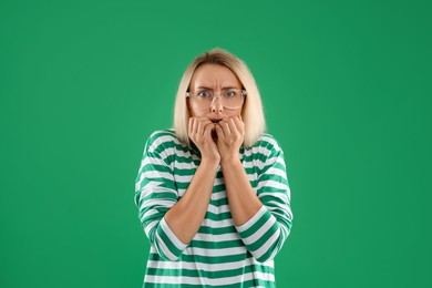 Portrait of scared woman on green background